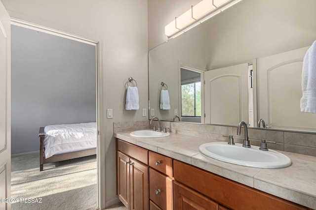 ensuite bathroom with double vanity, ensuite bath, and a sink