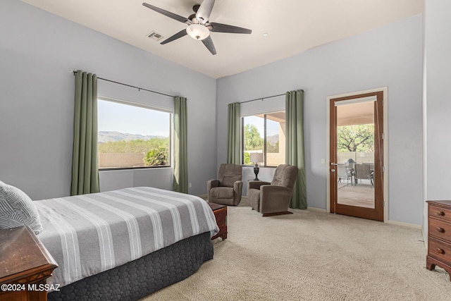 bedroom with ceiling fan, a mountain view, light colored carpet, and access to outside