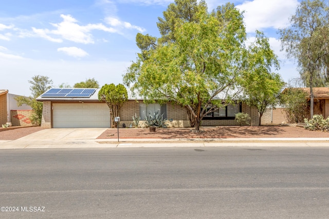 view of front of property with a garage and solar panels