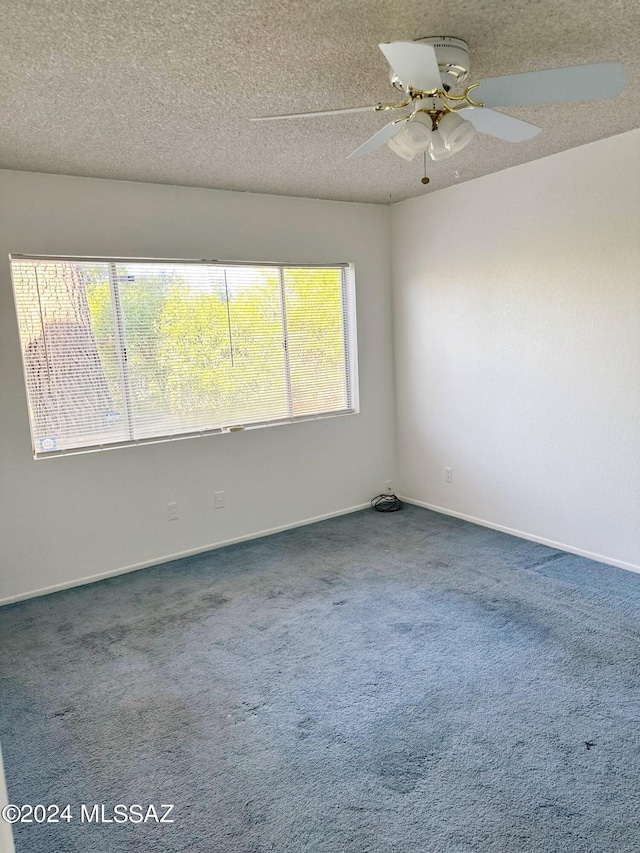 spare room with carpet, a wealth of natural light, and ceiling fan