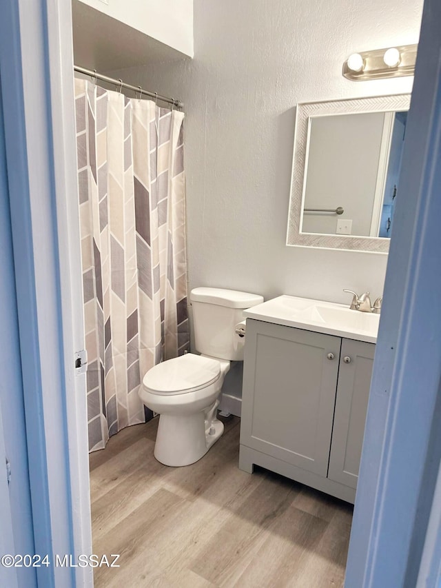 bathroom featuring hardwood / wood-style floors, vanity, and toilet