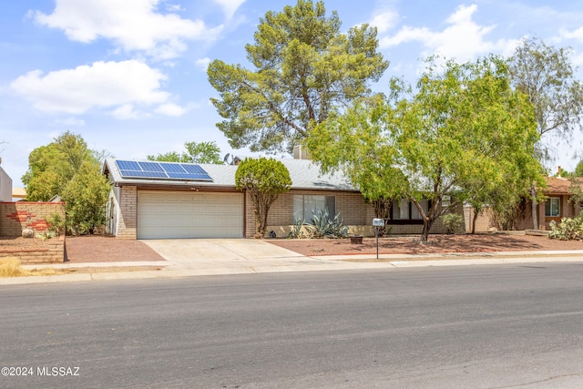 view of front of home featuring solar panels and a garage