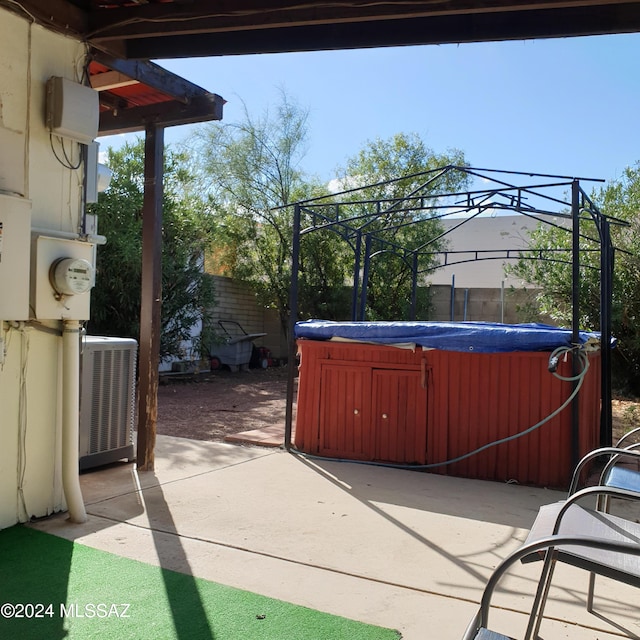 view of patio / terrace with a gazebo, cooling unit, and a hot tub