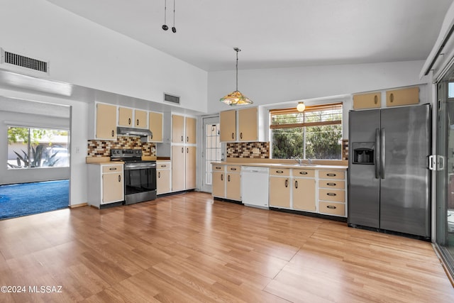 kitchen with backsplash, pendant lighting, stainless steel appliances, and sink