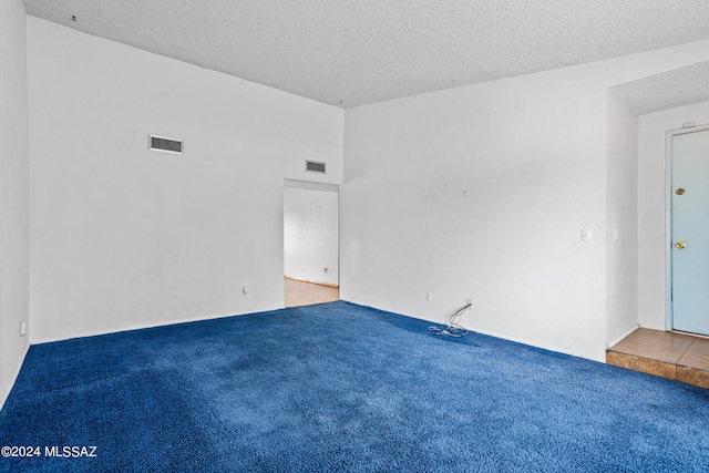 carpeted empty room featuring a textured ceiling