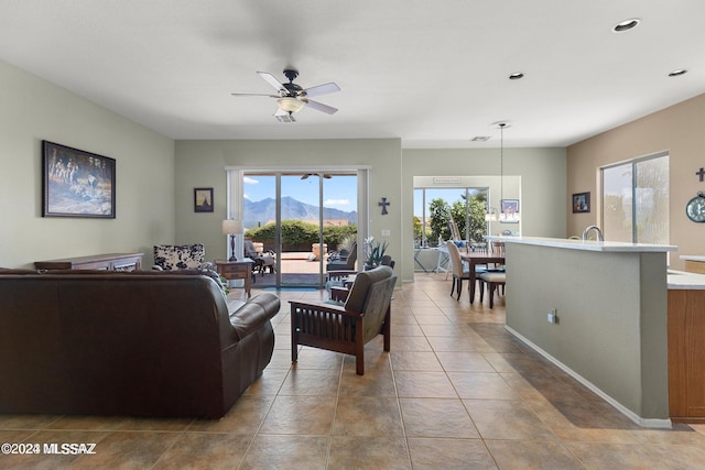 tiled living room featuring a mountain view and ceiling fan