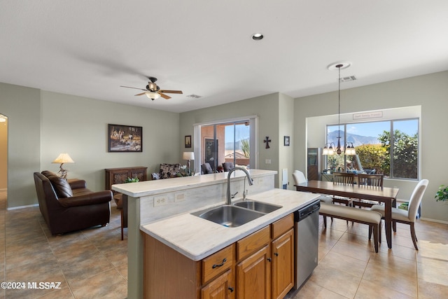 kitchen with pendant lighting, dishwasher, sink, an island with sink, and a wealth of natural light