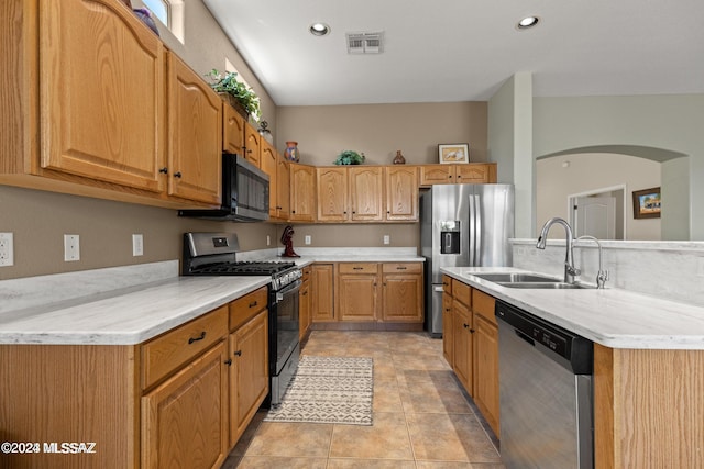 kitchen with appliances with stainless steel finishes, light tile patterned floors, and sink