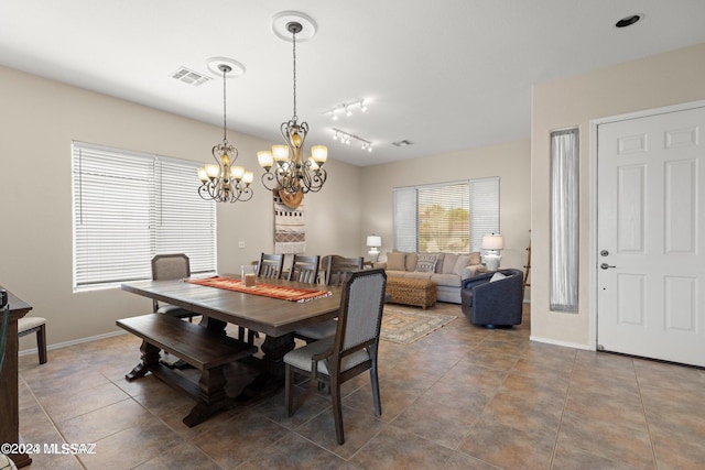 dining room featuring track lighting and an inviting chandelier