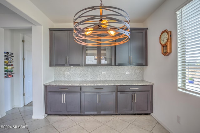 kitchen featuring tasteful backsplash, light stone countertops, and light tile patterned floors