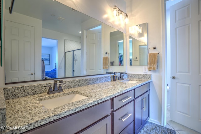 bathroom with tile patterned flooring, vanity, and walk in shower