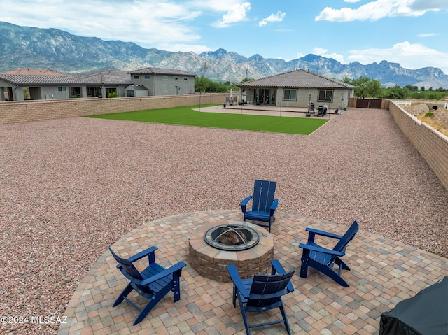 exterior space featuring a patio, a mountain view, and a fire pit