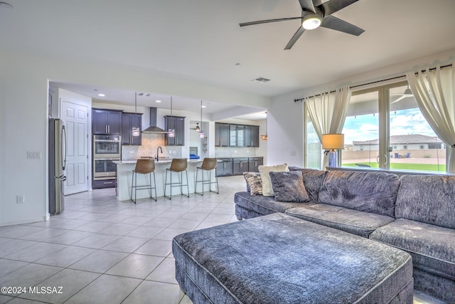 tiled living room featuring sink and ceiling fan