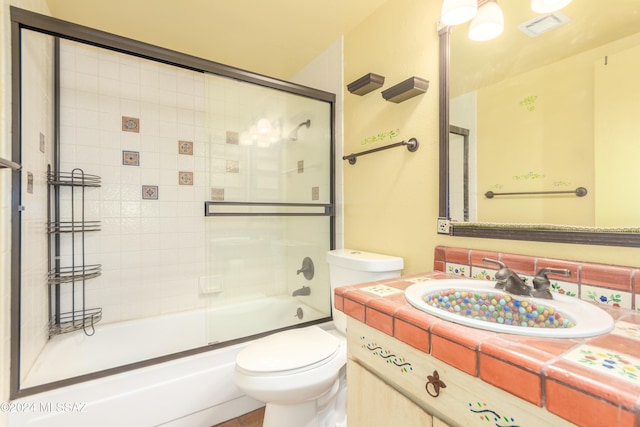 full bathroom with vanity, toilet, and enclosed tub / shower combo