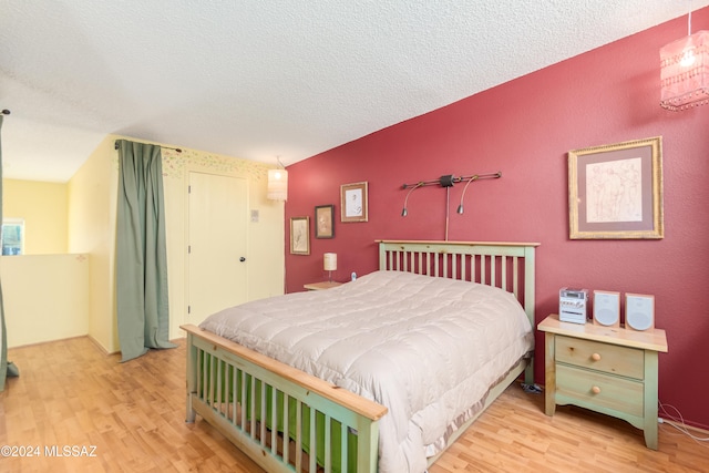 bedroom featuring a textured ceiling and light wood-type flooring