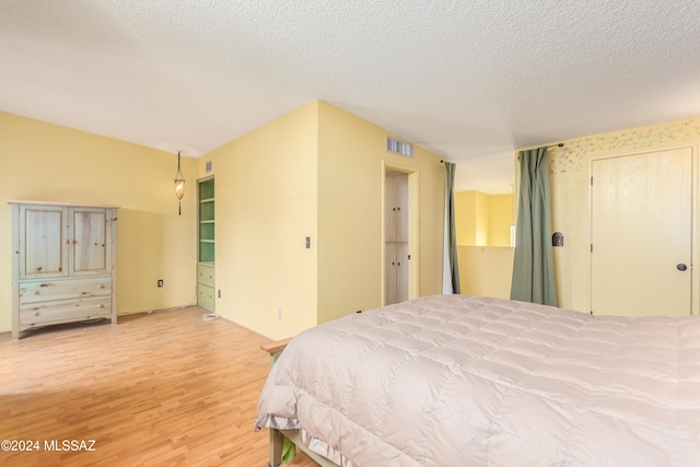 bedroom featuring light wood-type flooring and a textured ceiling