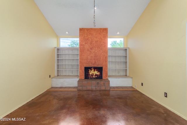 unfurnished living room featuring a fireplace, plenty of natural light, concrete flooring, and vaulted ceiling