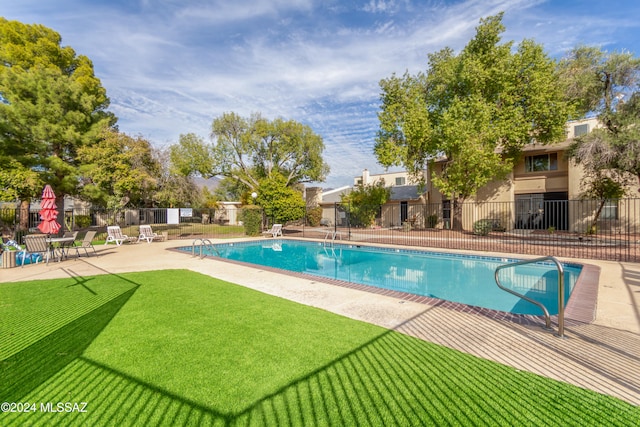 view of swimming pool featuring a lawn and a patio