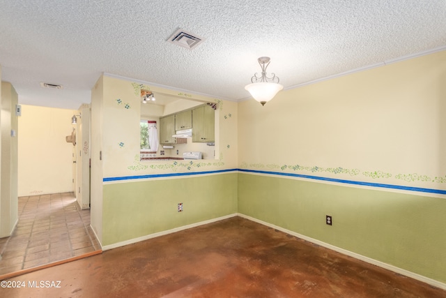 kitchen featuring concrete flooring, a textured ceiling, decorative light fixtures, and ornamental molding