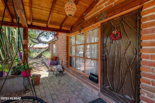 unfurnished sunroom with lofted ceiling with beams and wood ceiling