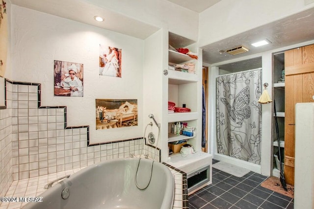 bathroom with tile patterned flooring, tile walls, and a tub to relax in