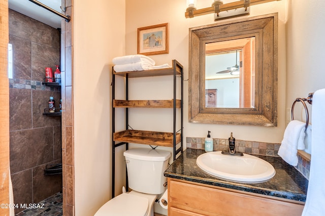 bathroom featuring vanity, toilet, and a tile shower