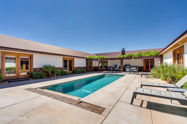 view of pool with french doors and a patio area