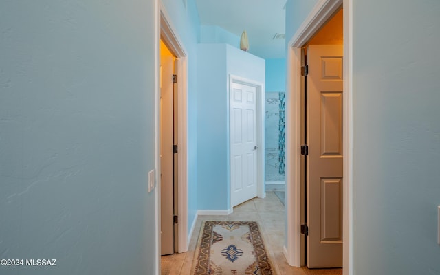 hall with light tile patterned floors