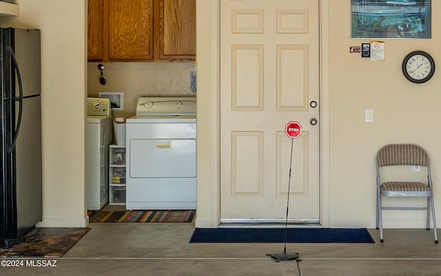 washroom featuring washing machine and clothes dryer and cabinets