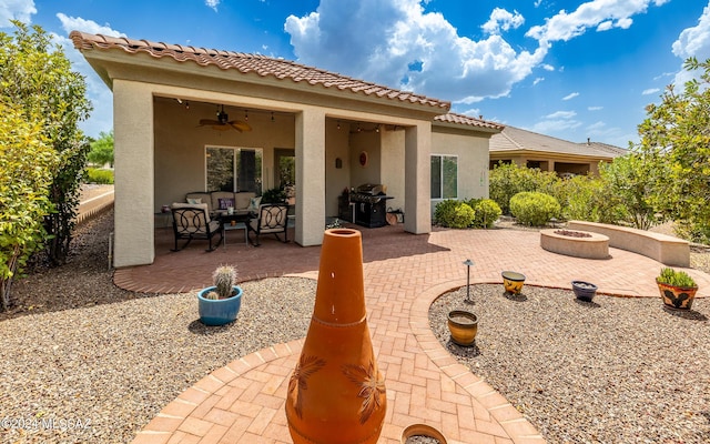 view of patio with grilling area, ceiling fan, and an outdoor living space with a fire pit