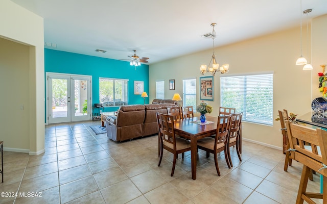 tiled dining room with french doors and ceiling fan with notable chandelier