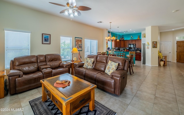 living room with light tile patterned floors and ceiling fan with notable chandelier