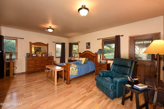 bedroom with multiple windows and light wood-type flooring