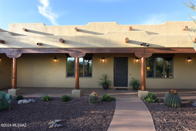 pueblo revival-style home featuring a patio area