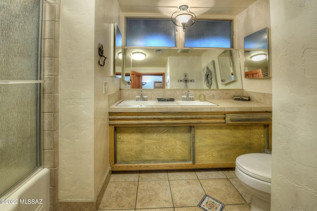 full bathroom featuring tile patterned floors, shower / bath combination with glass door, vanity, and toilet