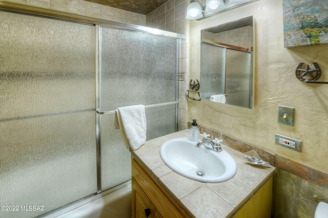 bathroom featuring vanity and shower / bath combination with glass door