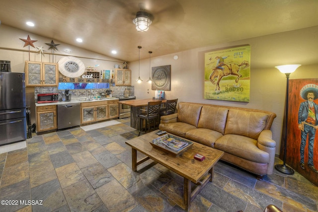 living room featuring ceiling fan, wet bar, and lofted ceiling