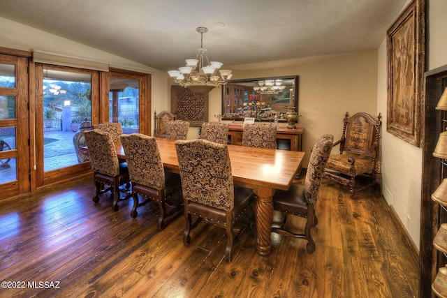 dining area featuring dark hardwood / wood-style floors, vaulted ceiling, and a chandelier