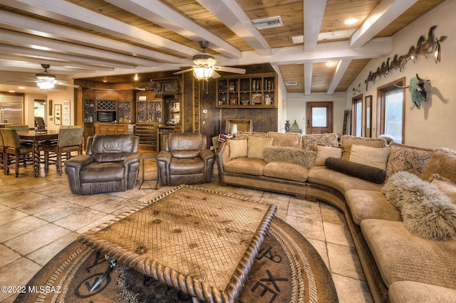 living room with beamed ceiling, ceiling fan, wood ceiling, and light tile patterned floors