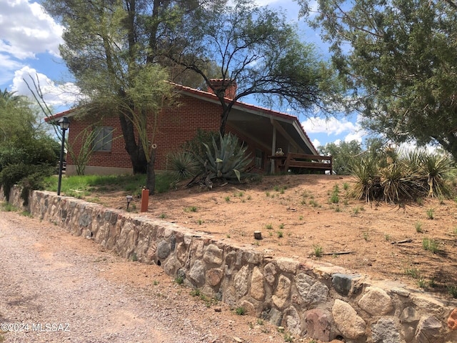 view of side of home featuring dirt driveway