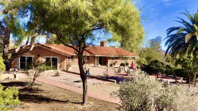 back of property featuring a chimney and a patio