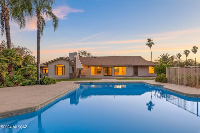 pool at dusk with a patio