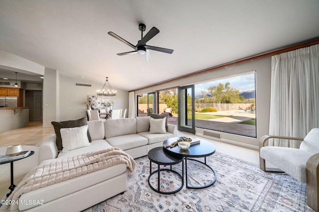 living room with vaulted ceiling and ceiling fan with notable chandelier