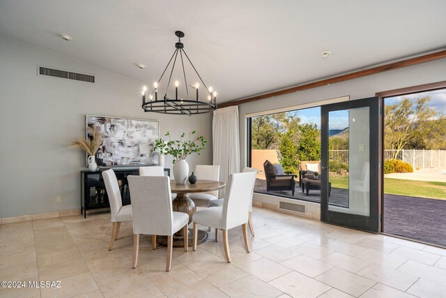 dining space with a chandelier and vaulted ceiling