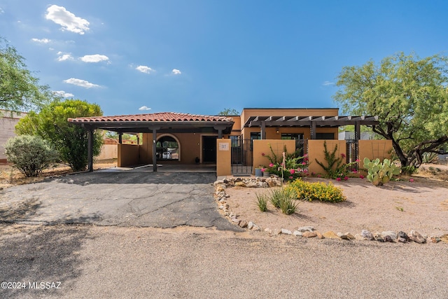 view of front of property featuring a gate, fence, a tiled roof, and stucco siding