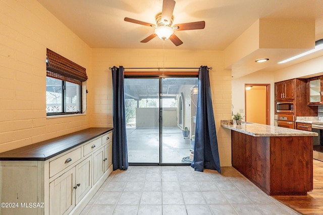 kitchen with stainless steel appliances, a ceiling fan, a peninsula, and tasteful backsplash