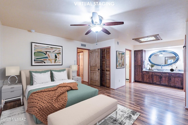 bedroom featuring ceiling fan, a closet, visible vents, and wood finished floors