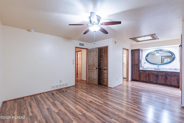 unfurnished bedroom featuring a closet, visible vents, ceiling fan, and wood finished floors