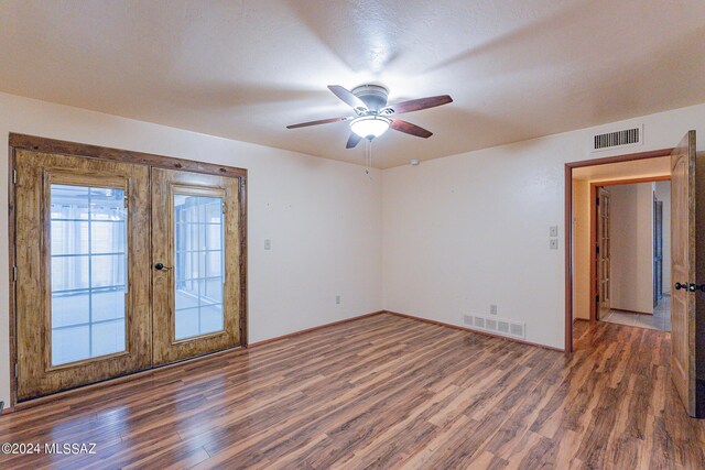 spare room featuring french doors, wood finished floors, and visible vents