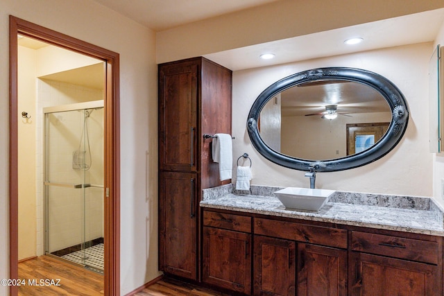 full bath featuring a stall shower, wood finished floors, vanity, and recessed lighting